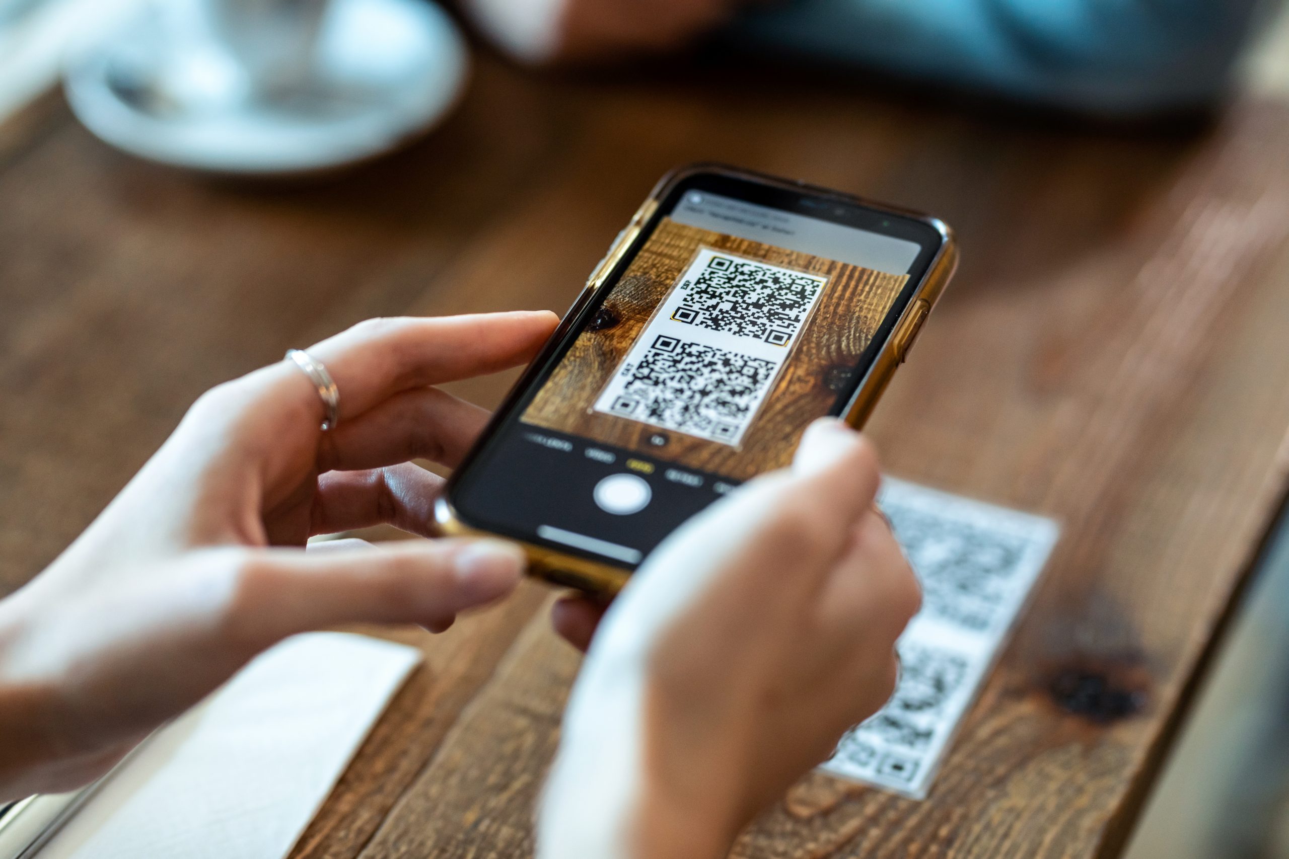 Close up of young woman hands using smart phone to scan a qr code to illustrate qr code benefits
