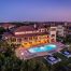 stunning drone view of a multi-family property and its amenities at twilight
