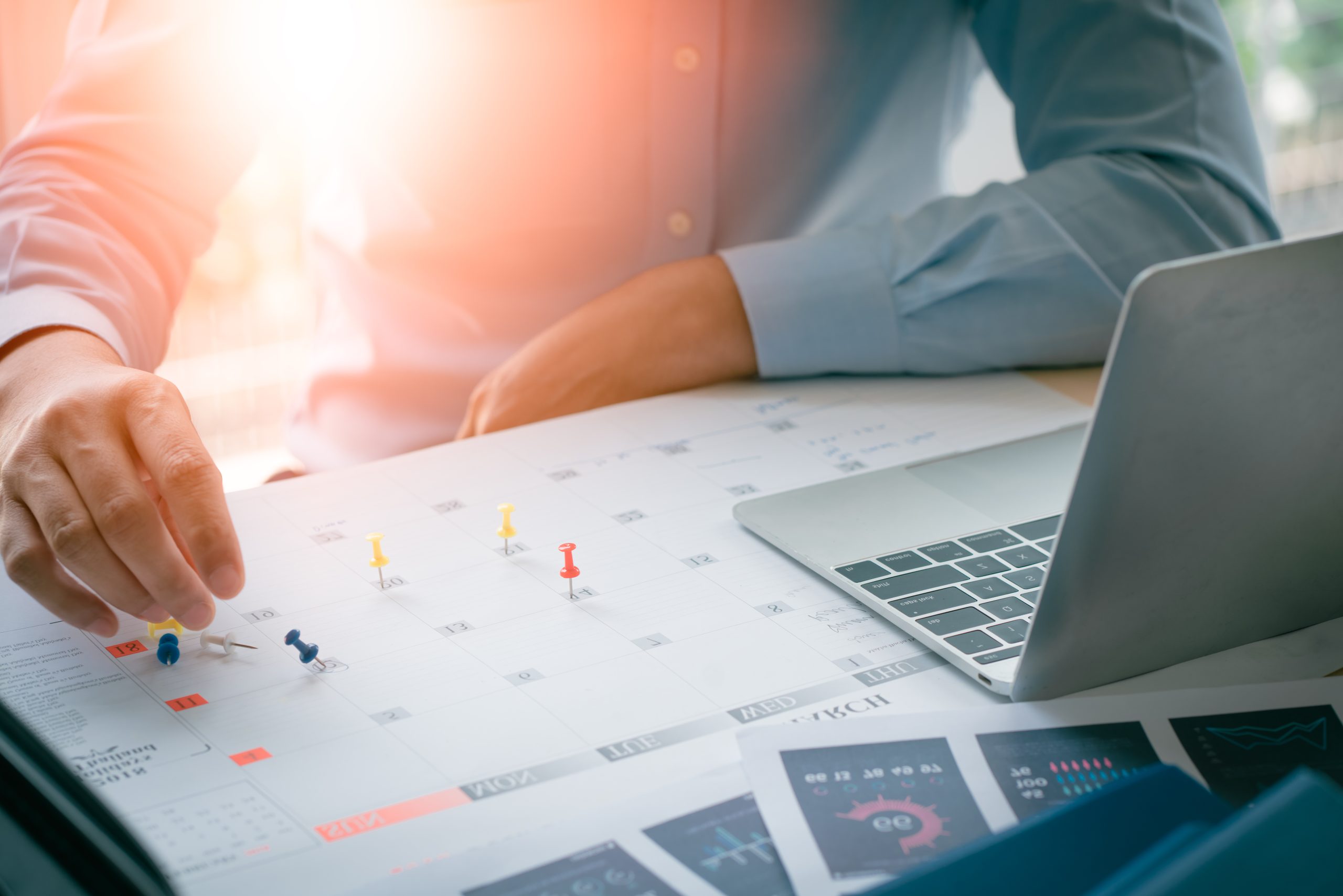 image of a man planning for a successful year on a computer and written calendar