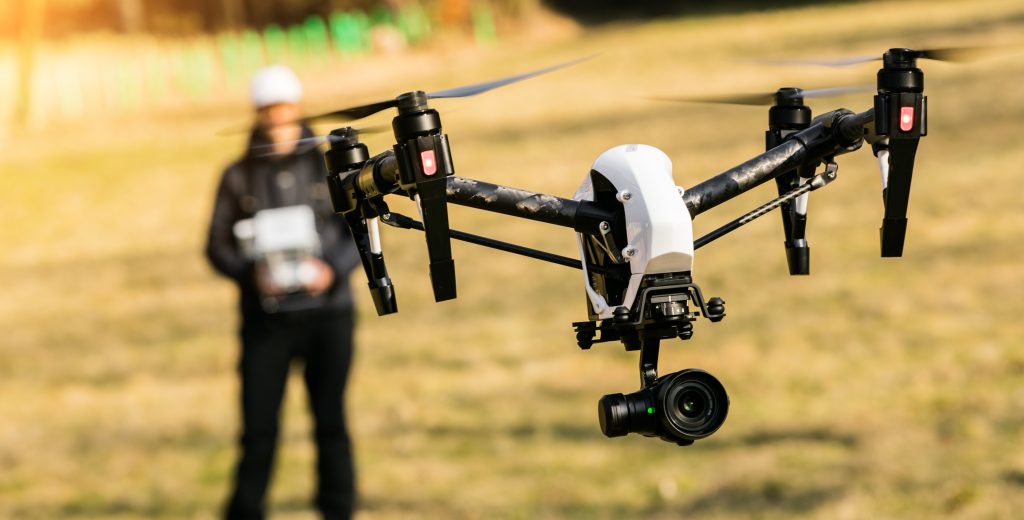 image of a drone in a field to show how to fly a drone