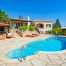 image of a clean and clear pool with a tuscan style home in the background to illustrate how to get your pool ready for summer