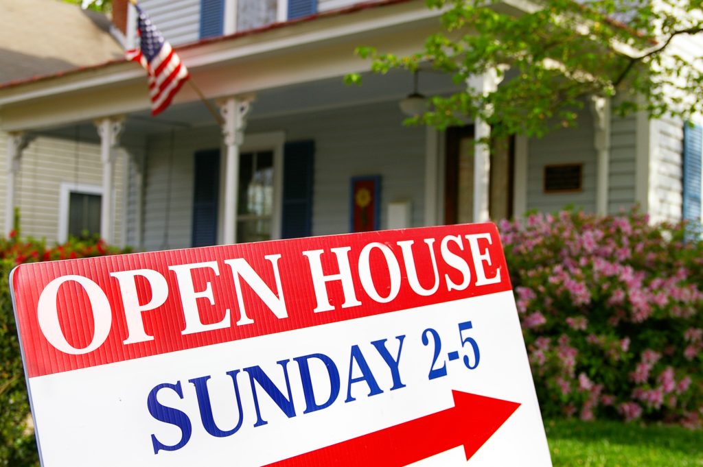 open house marketing sign with date and time in front of a home