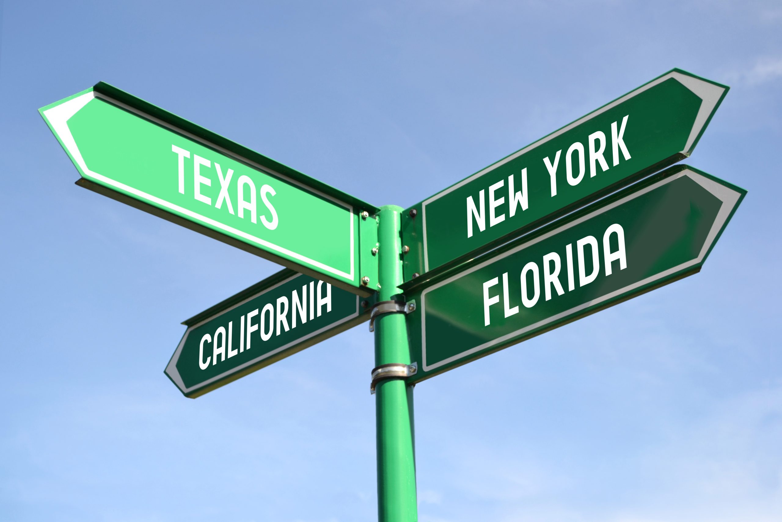image of directional signs pointing to different cities to illustrate real estate license reciprocity