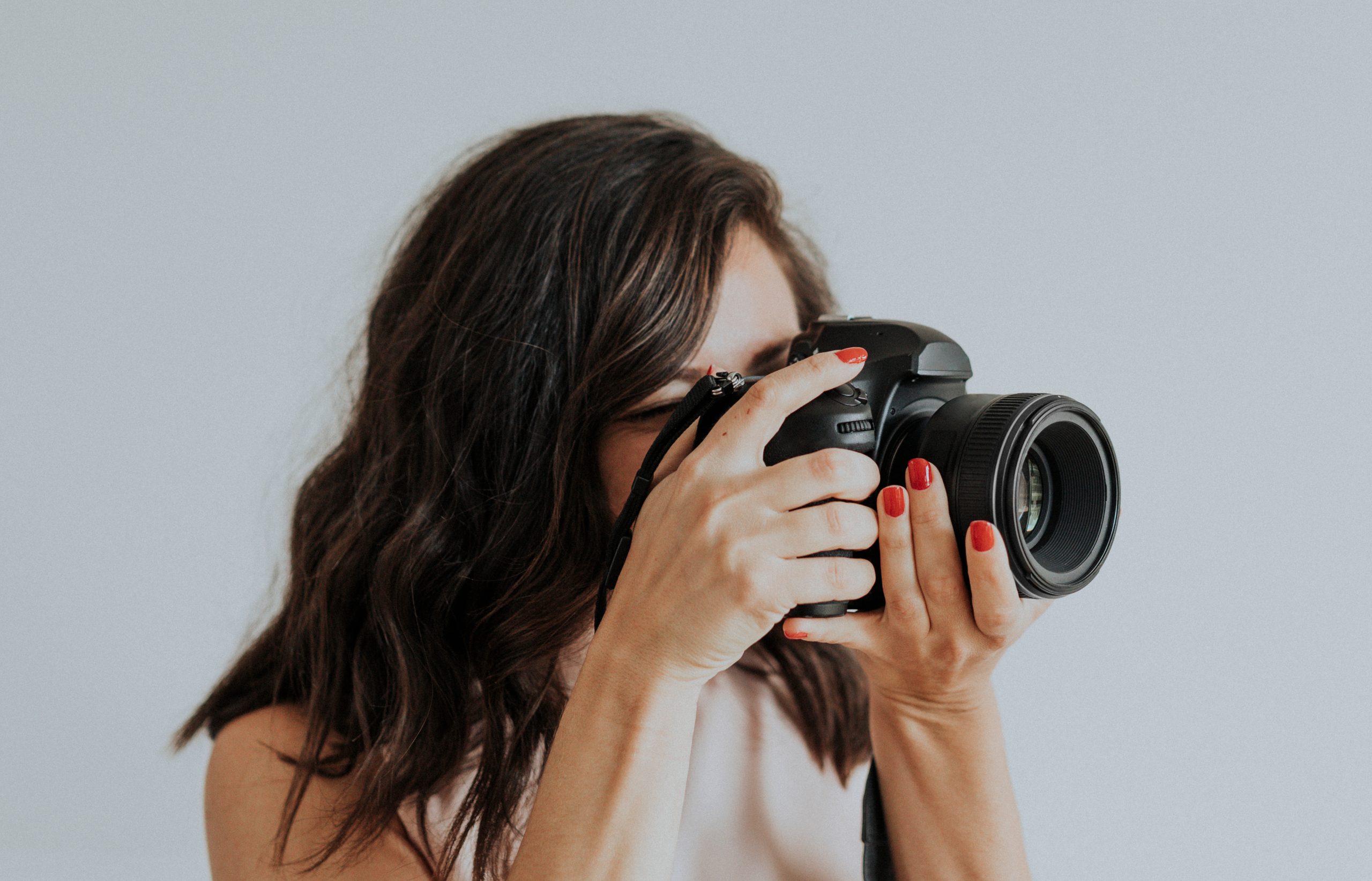 Female professional real estate photographer at a shoot holding digital camera