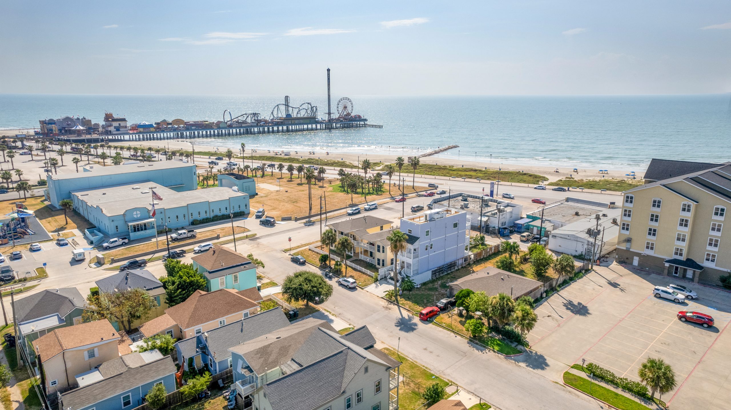 Square Foot's Best Real Estate Photos - aerial view of a property with nearby Galveston beach and pier with amusement rides