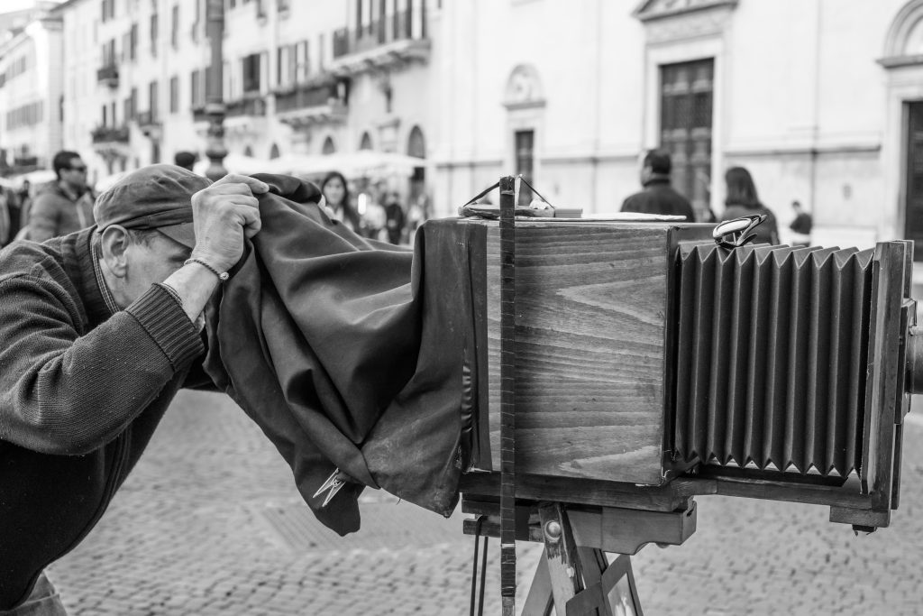 History of photography: Man taking photo with old camera